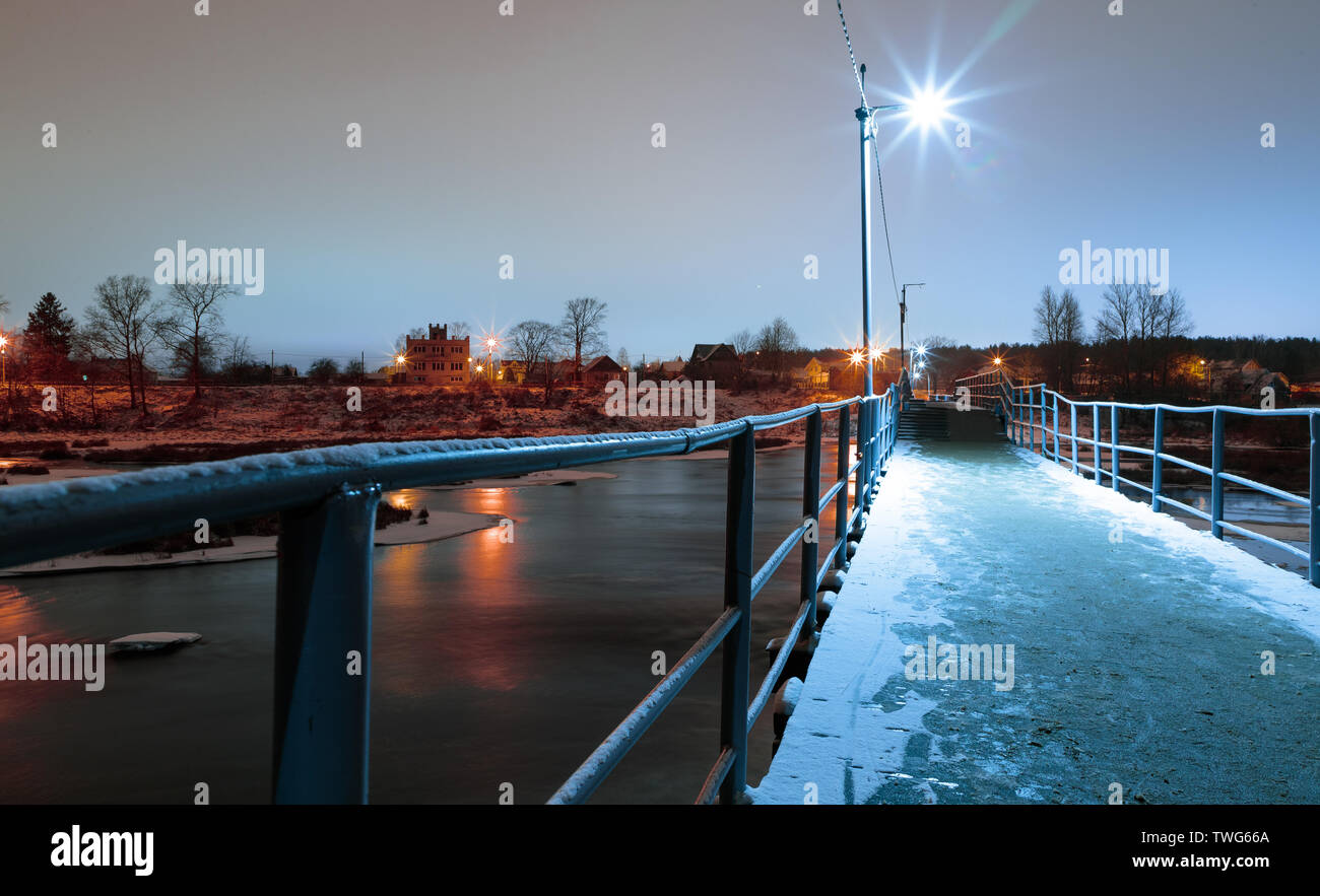 Fußgänger-Brücke über den Fluss Am Abend im Winter Stockfoto