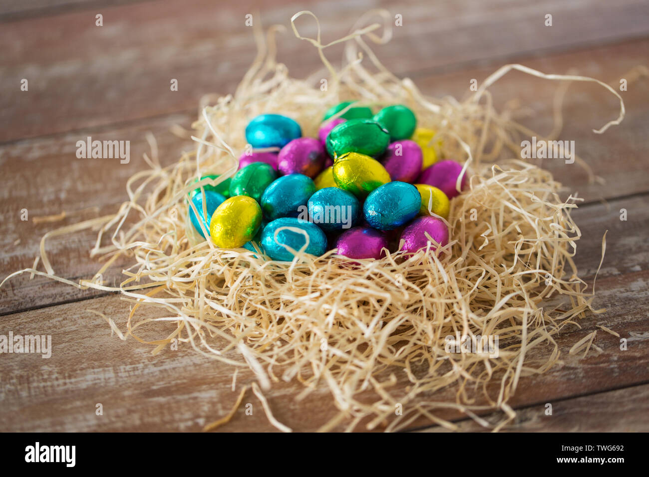 Schokolade Eier in Folie Wrapper in Stroh Nest Stockfoto