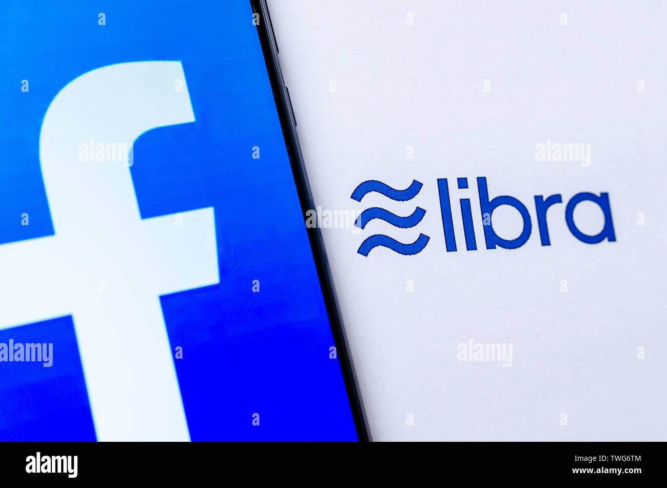 Facebook Libra ist eine neue crypto Währung. Das Foto von Smartphone mit Facebook Logo auf tge Bildschirm und die Waage Logo auf dem Prospekt. Stockfoto