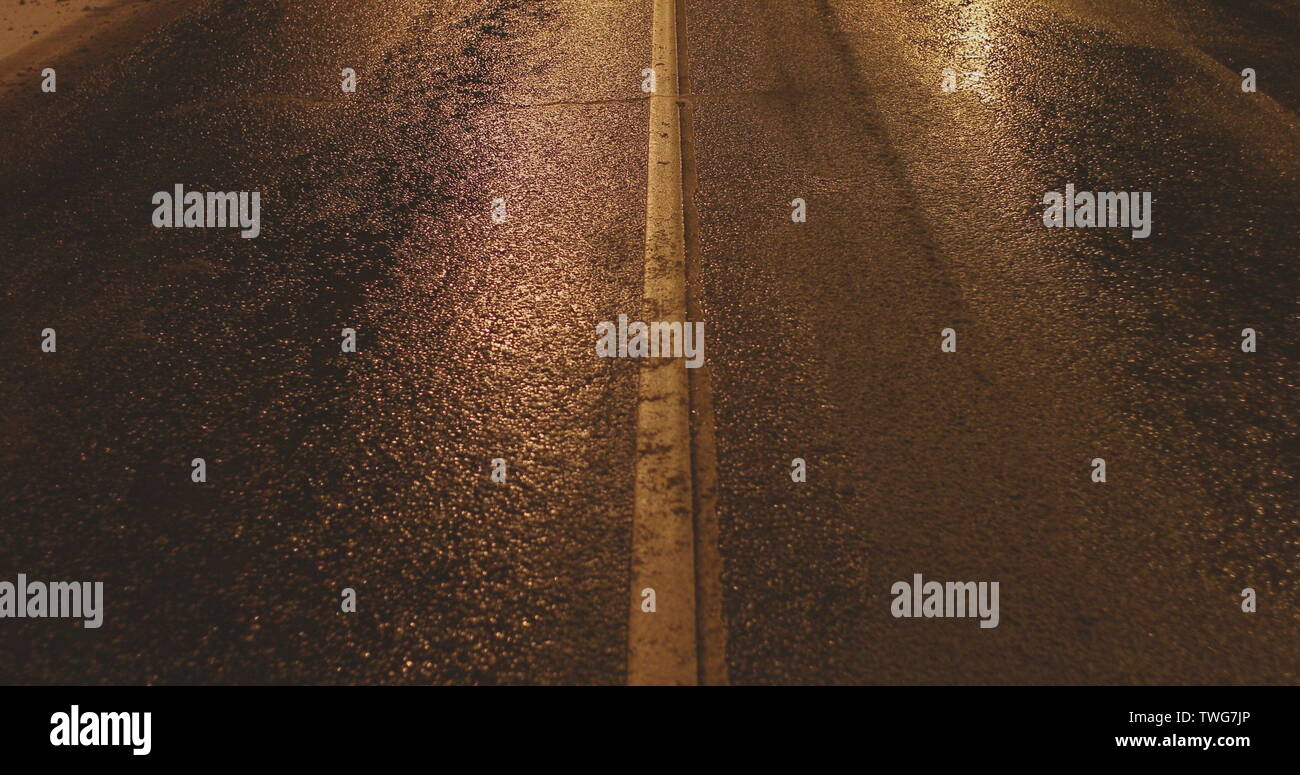 Schmutzige Asphaltstraße im Herbst bei Nacht Stockfoto