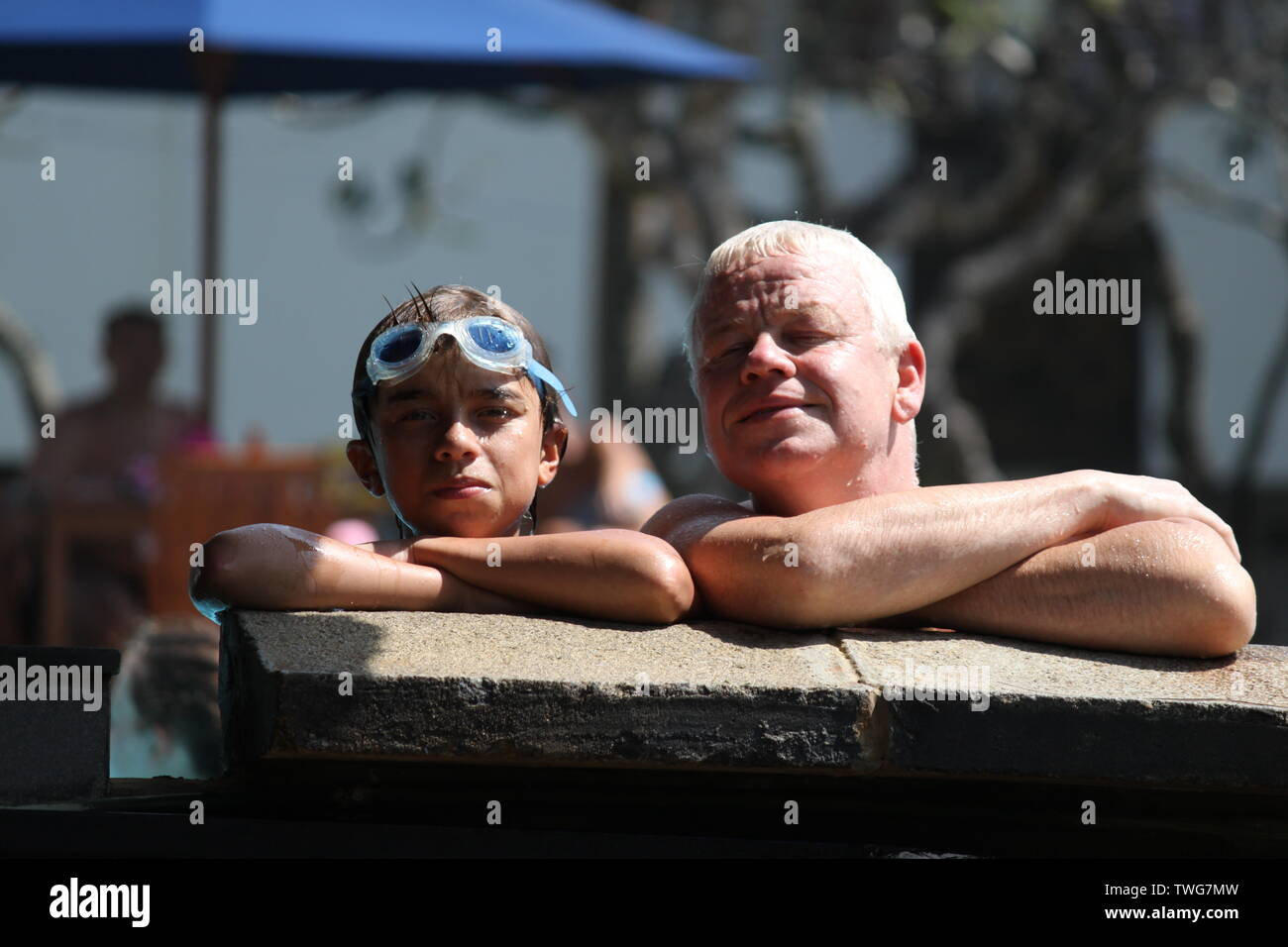 Portrait von Vater und Sohn posiert am Rand von einem Pool in einem Holiday Resort in Sri Lanka Stockfoto