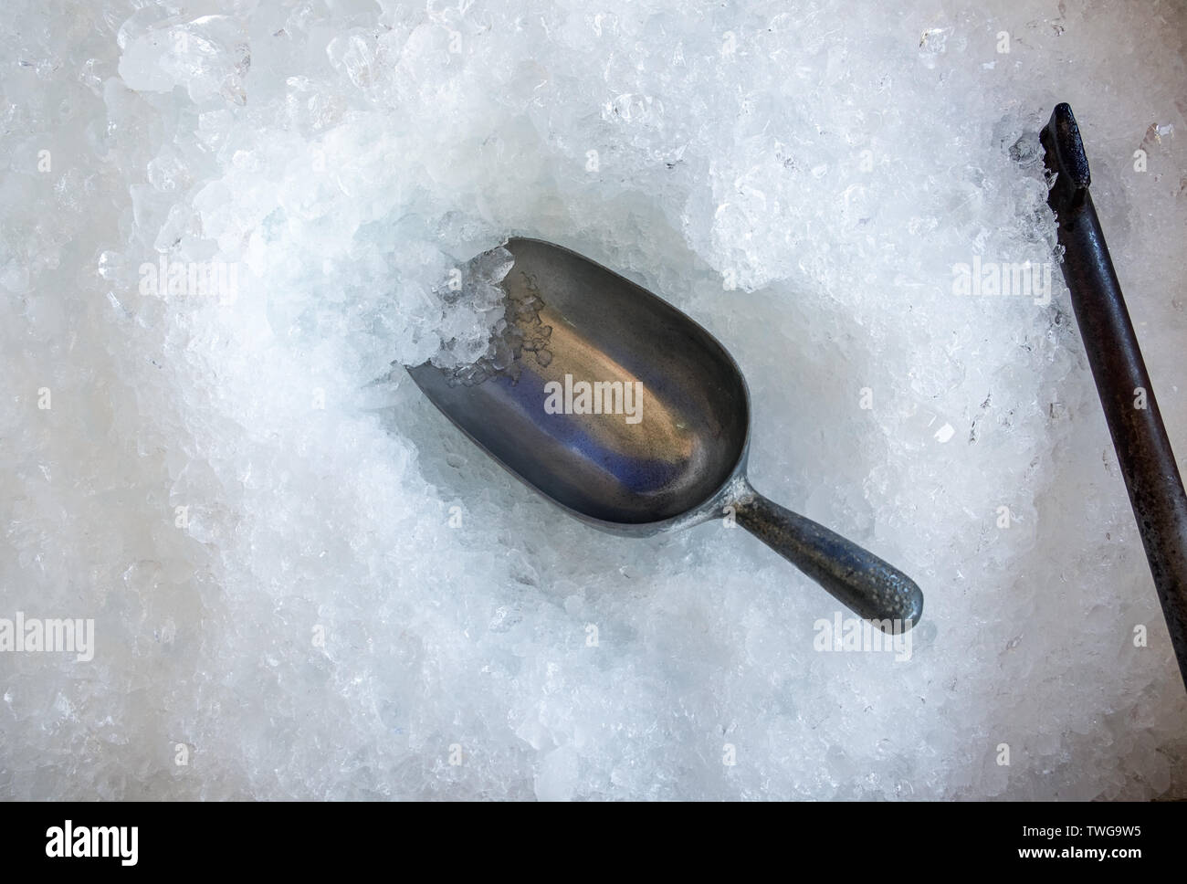 Metalllöffel in Eis flake Cube und alten Ax Stockfoto