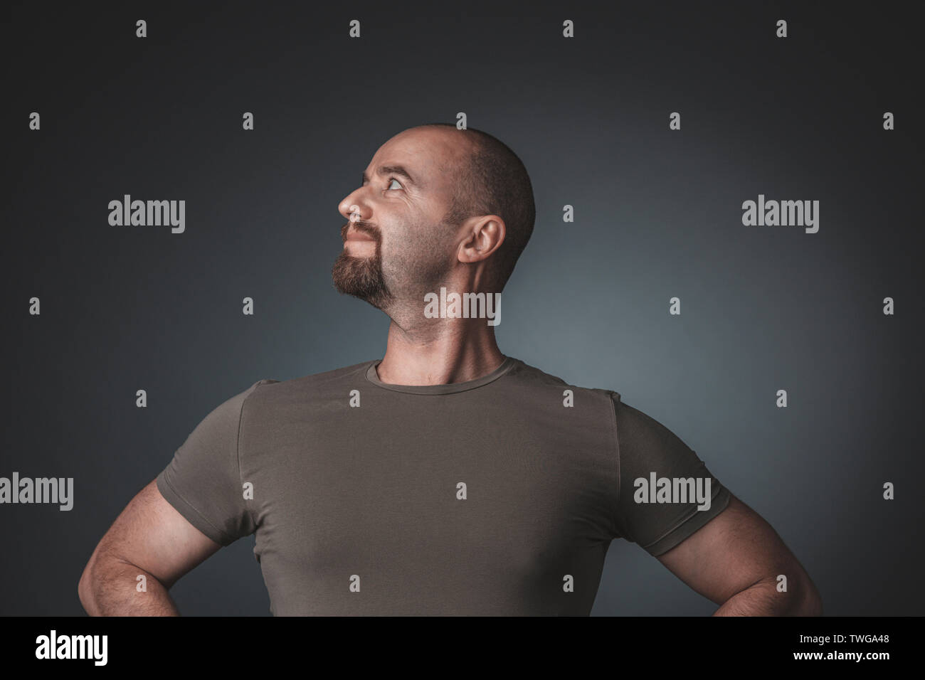Studio Porträt eines Mannes mit einem zufrieden und stolz Ausdruck, Seitenansicht, mit den Händen auf den Hüften und Brust heraus stellen. Stockfoto