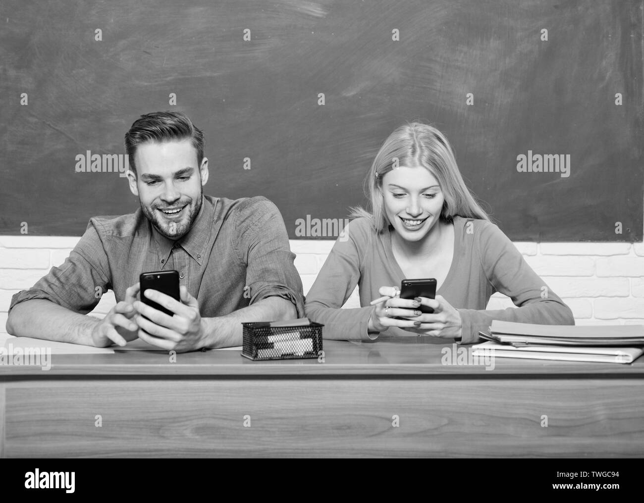 Digitale Welt. Heimschule. Paare von Mann und Frau im Klassenzimmer. Zurück zu Schule. Moderne Schule. Kenntnisse täglich. Das studentische Leben. Lektion und die Tafel. Lehrer Tag. Glückliches Paar. Stockfoto