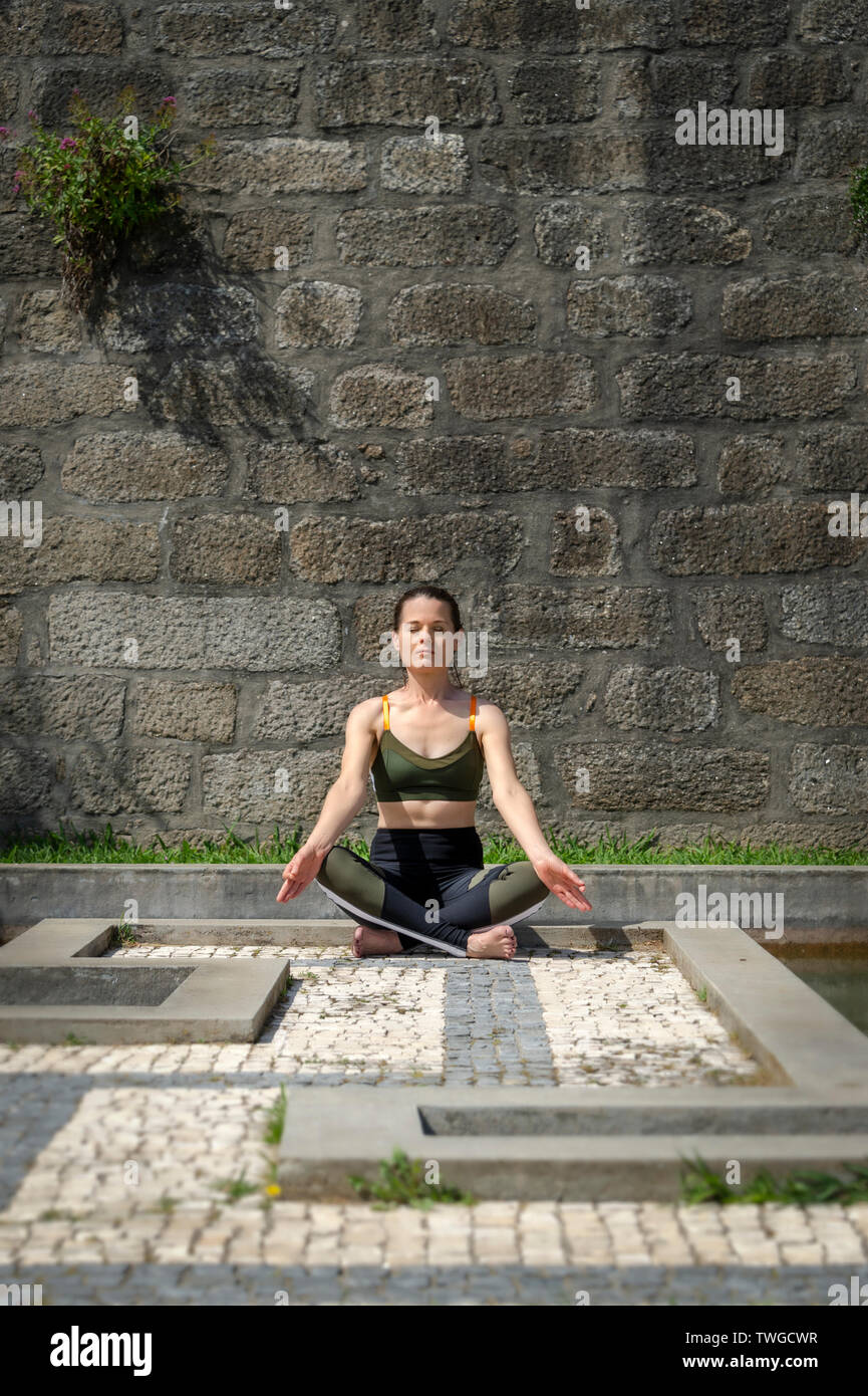Frau meditieren außerhalb Yoga in einer prunkvollen Garten Stockfoto
