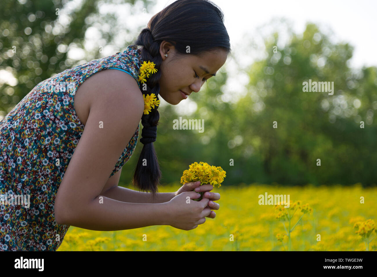 Ein schönes junges Mädchen mit Blumen im Haar macht einen Blumenstrauß in Fort Wayne, Indiana, USA. Stockfoto