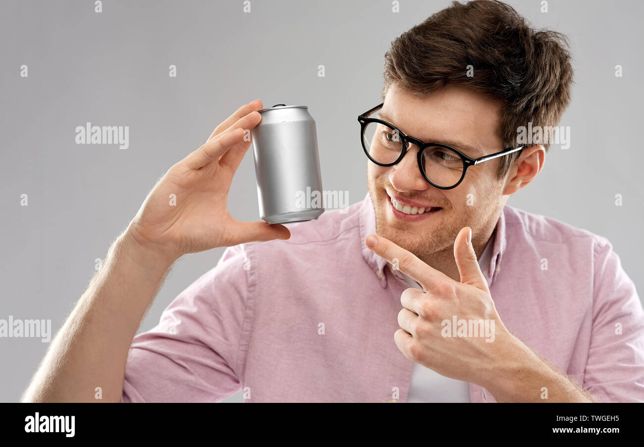 Glückliche junge Mann Zinn Holding kann mit Soda Stockfoto
