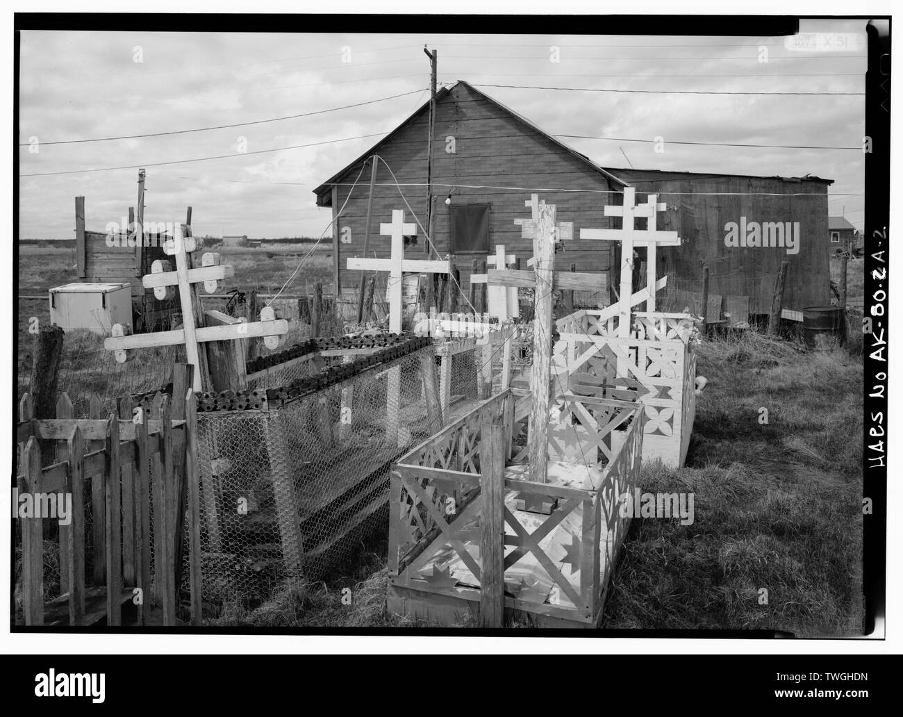 Pfarrhaus, Ostseite, GRÄBER IM VORDERGRUND - St. Jakob, Russische Orthodoxe Kirche, Kirchhof, Napaskiak, Bethel Census Area, AK Stockfoto