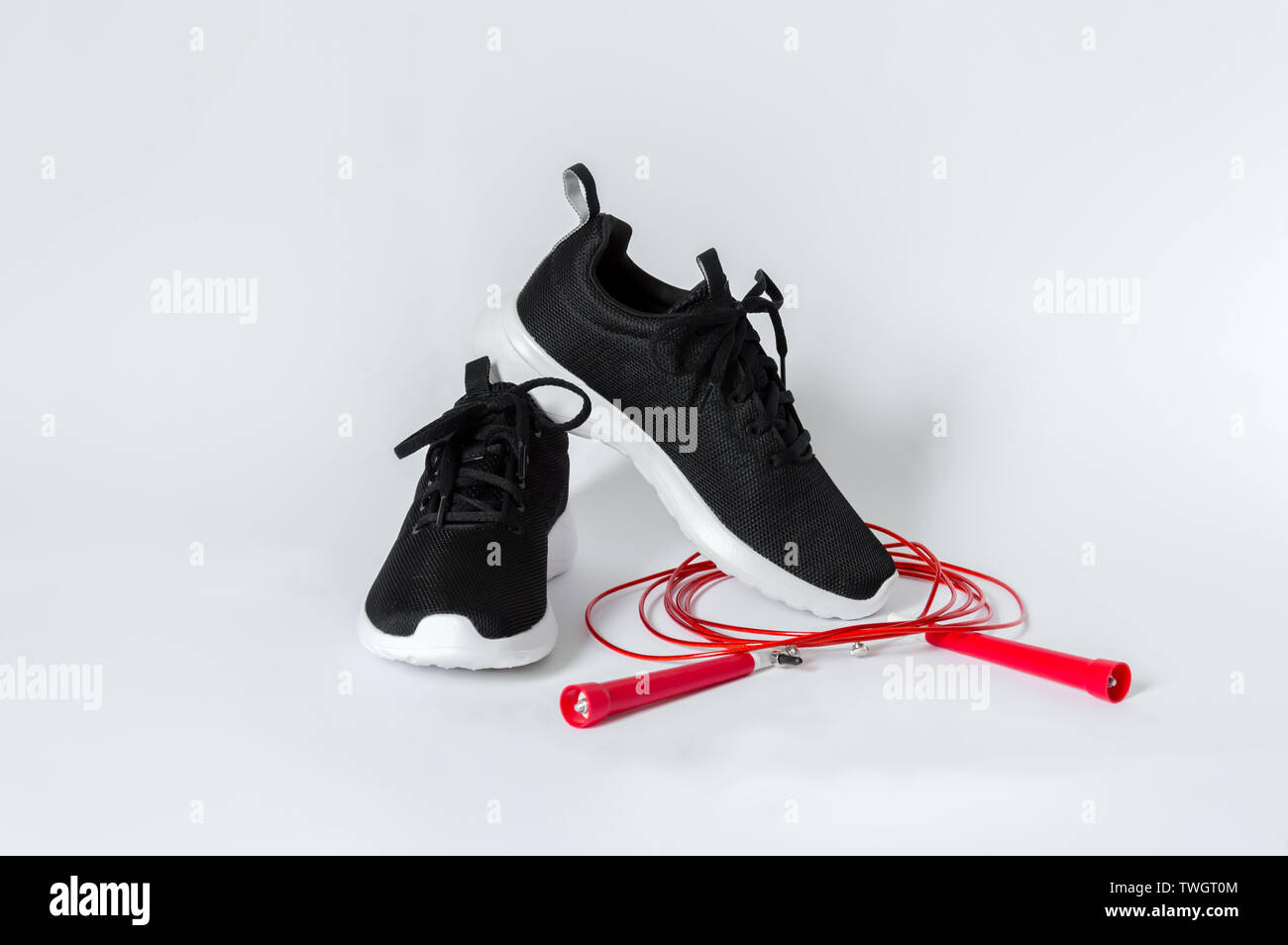 Schwarz sport Turnschuhe mit weißer Sohle und roten Seilspringen auf weißem  Hintergrund. Konzept der Fitness und gesunde Lebensweise Stockfotografie -  Alamy