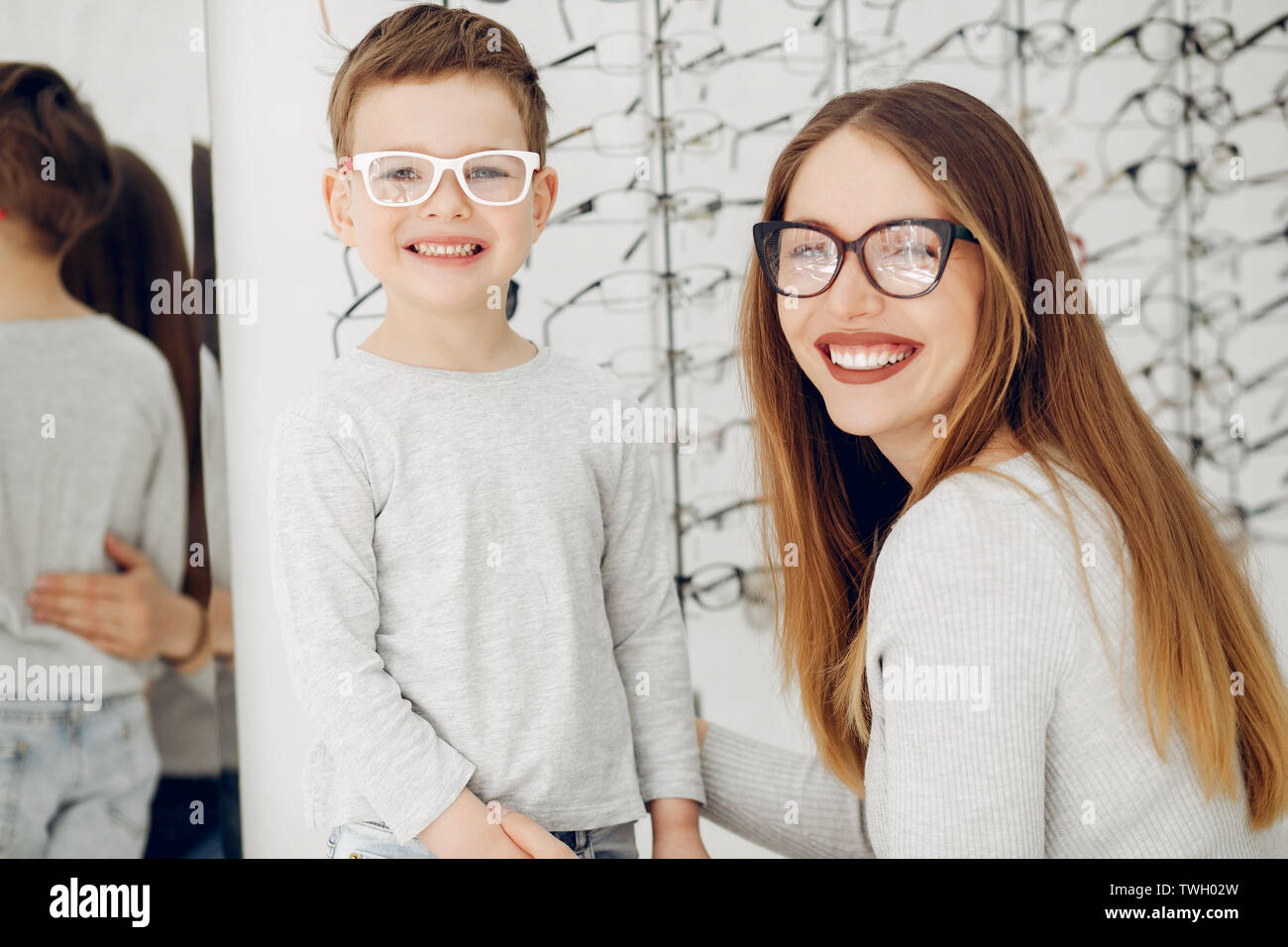 Mutter mit kleinen Sohn in die Gläser store Stockfoto