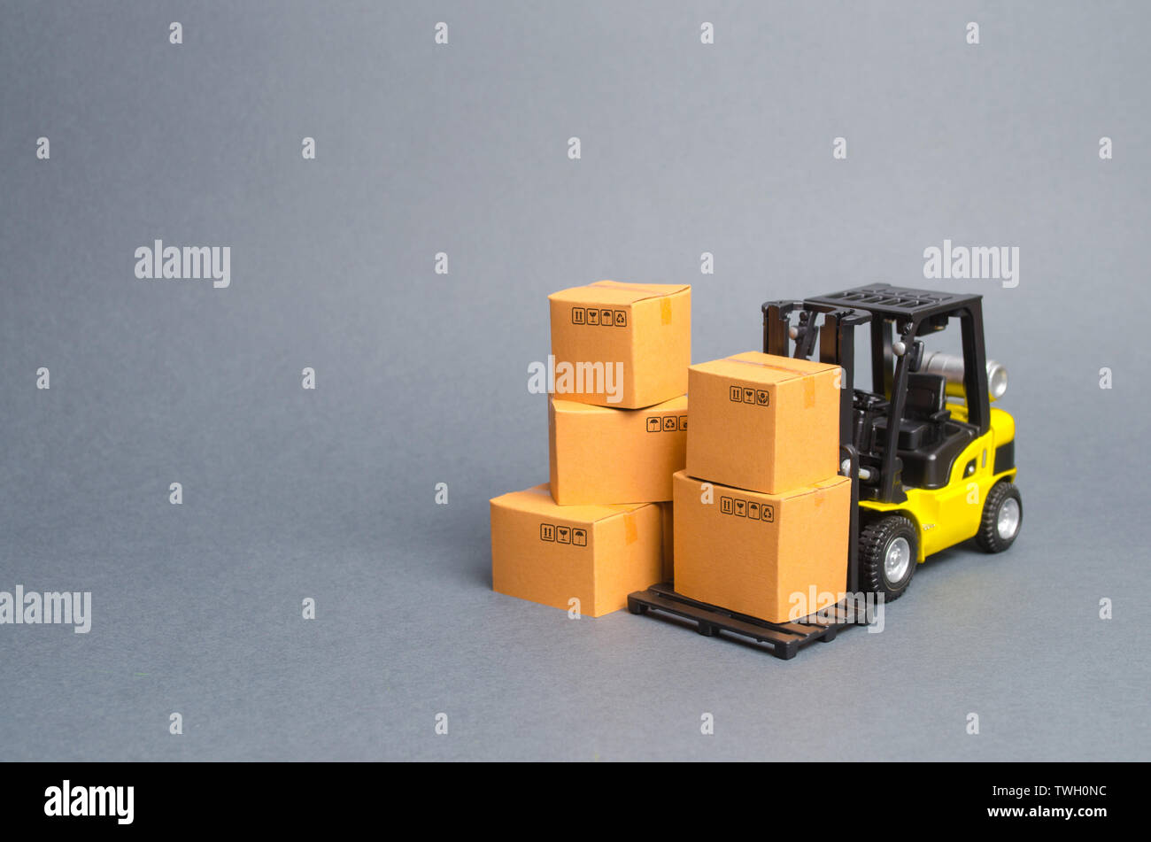 Gelbe Gabelstapler mit Kartons. Service Lagerung von Waren in einem Lagerhaus, Lieferung und Transport. Fracht und Lieferung. Importieren Sie ein Stockfoto