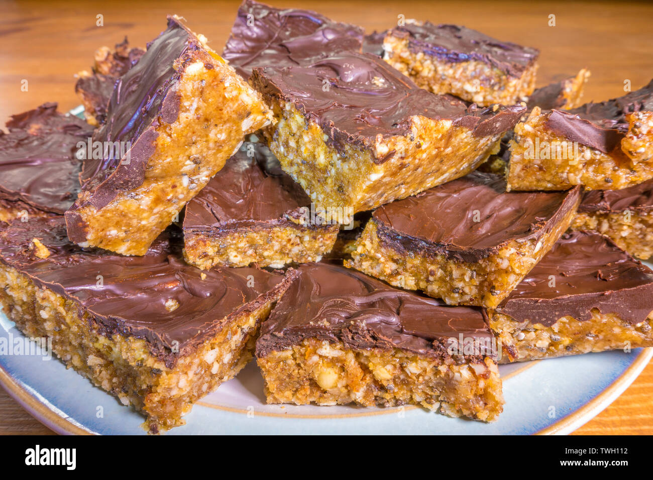 Ein Teller von Chewy, gehackt Cashew und Kokosnuss, Schokolade aufgefüllt Dessert Quadrate. Stockfoto