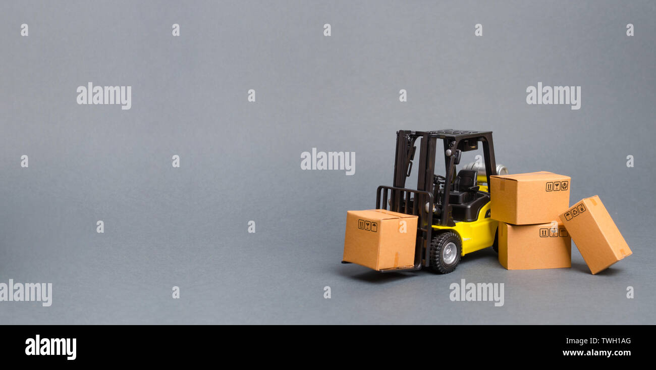 Gelbe Gabelstapler mit Kartons. Vertrieb, Produktion von Gütern. Transport, Lagerung von Gütern und Waren zu erhöhen. Fracht, liefern Stockfoto