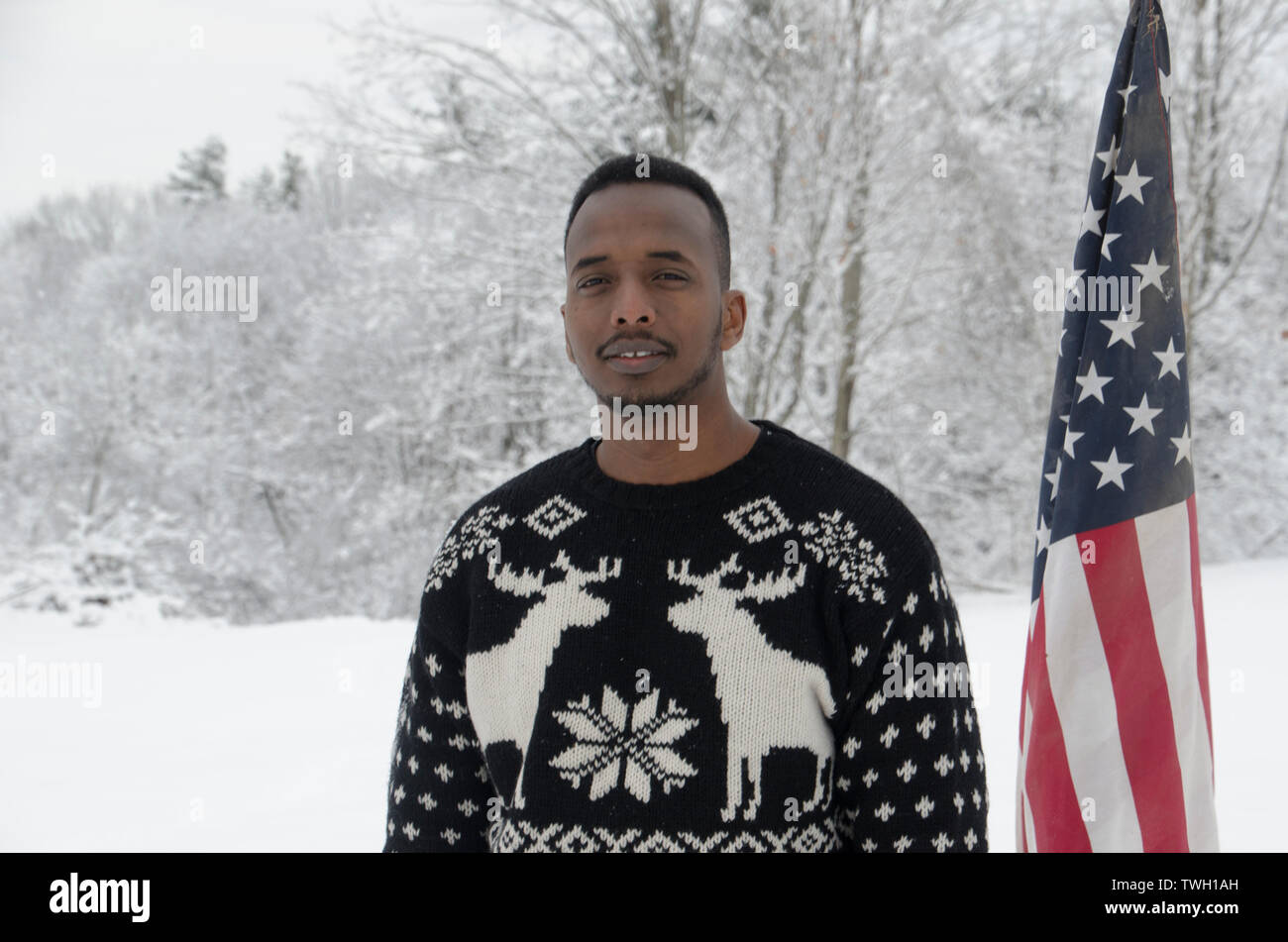 Somalischer Immigranten und Autor, Abdi Nur Iftin, schneebedecktes Feld mit amerikanischer Flagge, Yarmouth, Maine Stockfoto