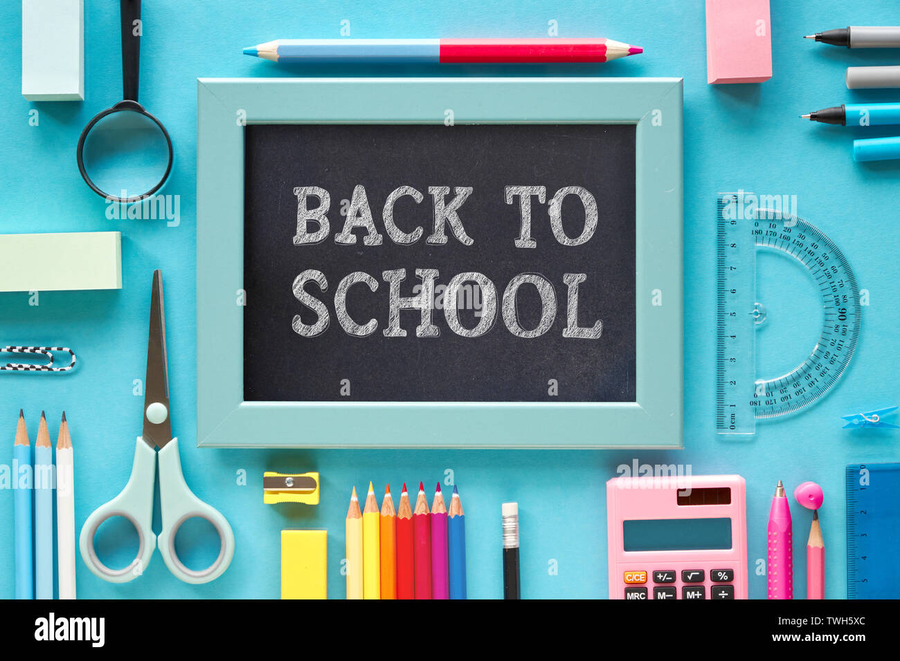Flach Konzept Hintergrund "Zurück zur Schule". Stationäre Punkte auf blauem Papier Hintergrund, Kreide Text auf dem Schwarzen Brett. Stockfoto