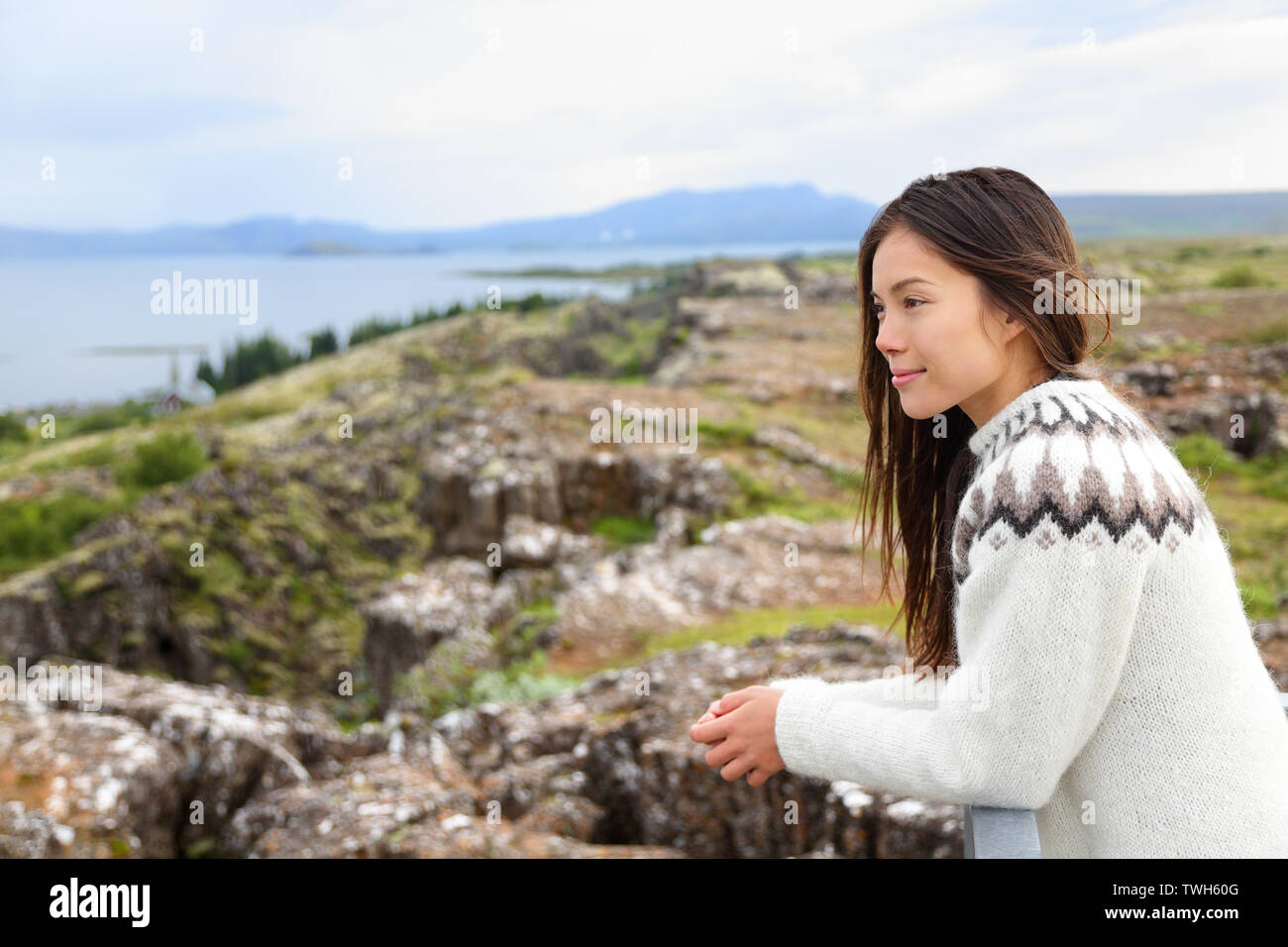 Island - die Frau, die in der isländischen Pullover bei Thingvellir Ort der Althing, das erste Parlament der Welt. Mädchen an Touristen Destination Sightseeing. Stockfoto