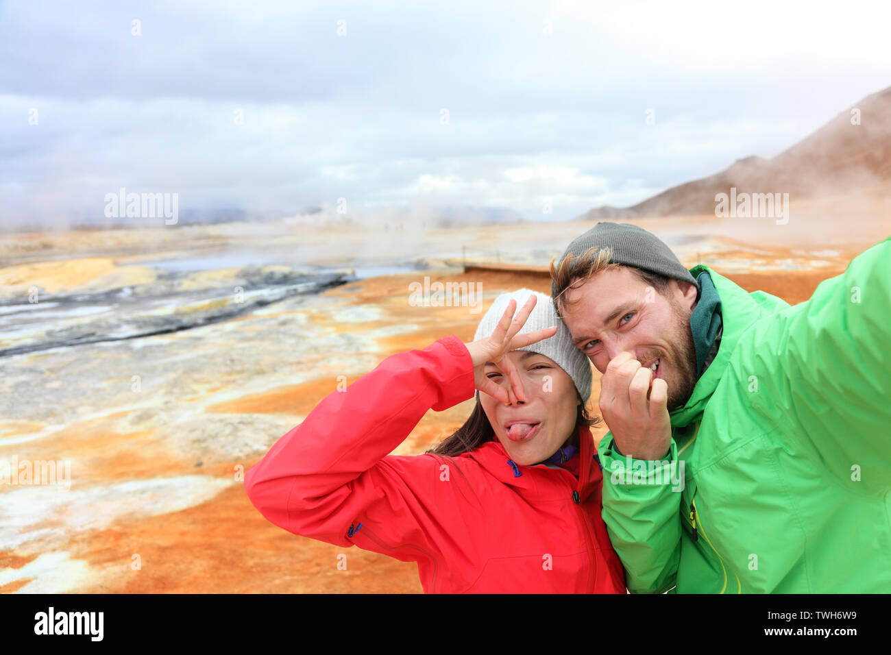 Island lustige Touristen paar Spaß unter selfie Foto mit im Landmark Ziel: namafjall Hverarondor mudpot hverir auch als Schlammbad hot spring oder fumarole. Geruch von Schwefel auf Vulkan Stockfoto