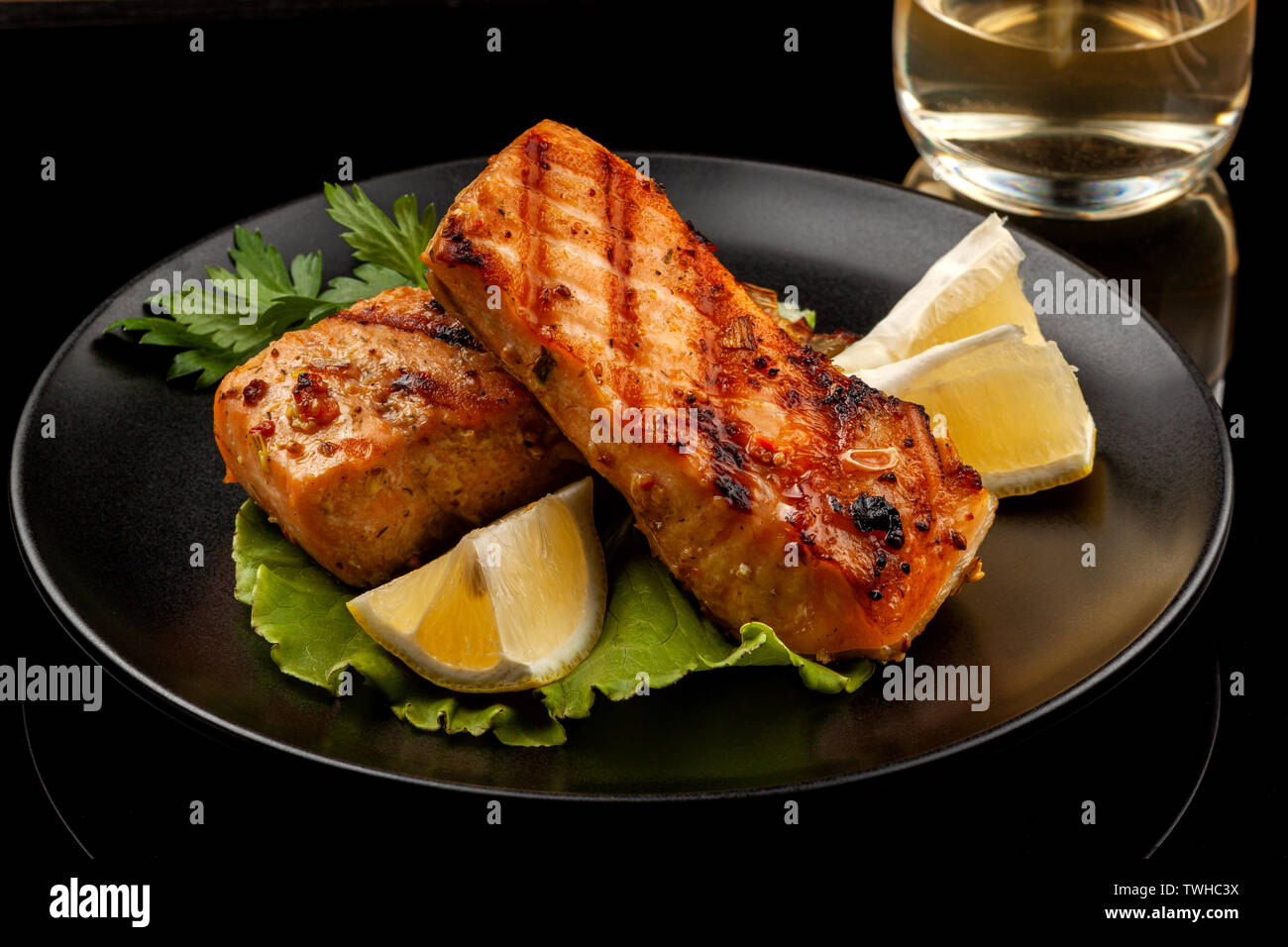 Fisch, Forelle, chum salmon, Buckelwale, ein Stück gebacken, gegrillt, mit einer Scheibe Zitrone und Salat Stockfoto