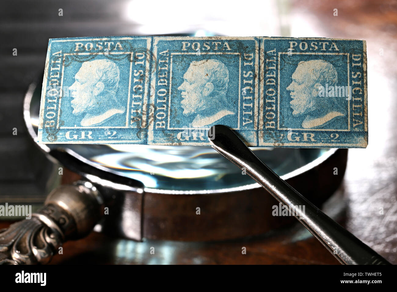 Streifen von 3 Königreich Sizilien 2 Grana Briefmarken ab 1859 durch Pinzette gehalten. Stockfoto