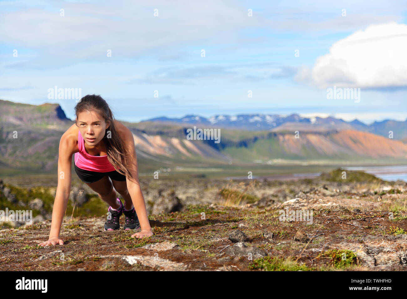 Push-ups fitness Frau tun pushups oder Plank außerhalb in atemberaubender Natur Landschaft auf Island. Passform weiblichen Sport Modell Mädchen training crossfit im Freien. Gemischte Rasse asiatischen Kaukasischen Athleten in ihrem 20s. Stockfoto