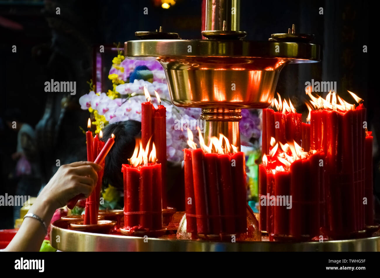 Frau leuchten rote Kerzen in der Buddhistischen Tempel, Taiwan, China. Religiöses Konzept, Spiritualität, glaube, Gott. Buddha Symbol Asien asiatische Religion. Stockfoto