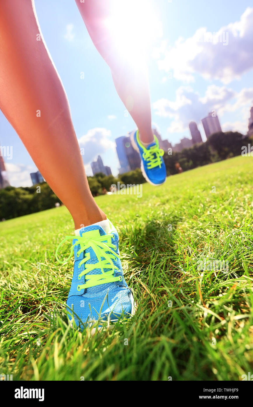 Runner - Laufschuhe Nahaufnahme der Sportlerin Laufschuhe auf Gras. Weibliche jogger Damenschuhe im Central Park, New York City. Stockfoto