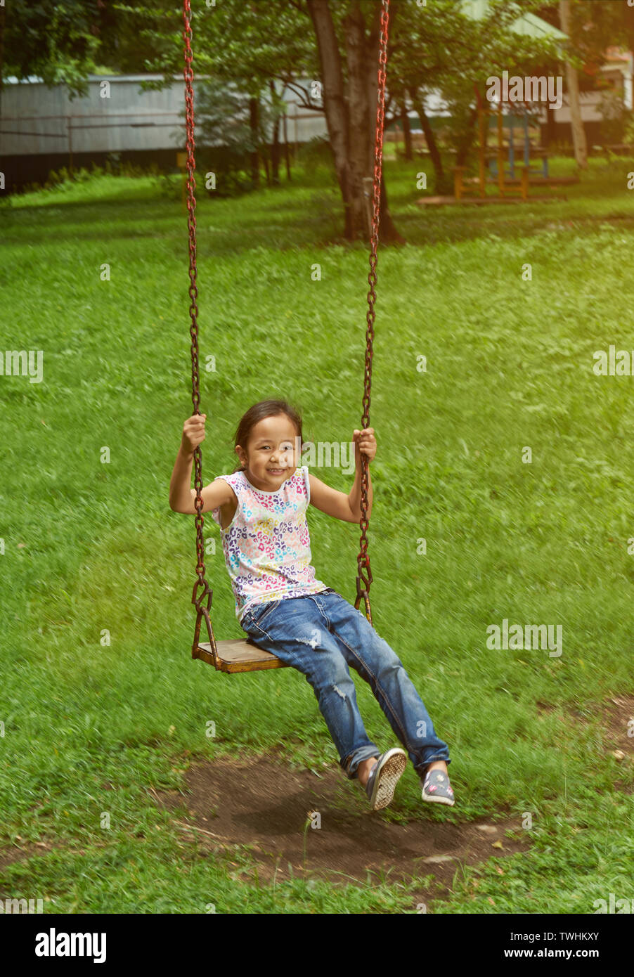 Asiatische Mädchen auf der Schaukel an einem Park. Filipina Kid. Stockfoto