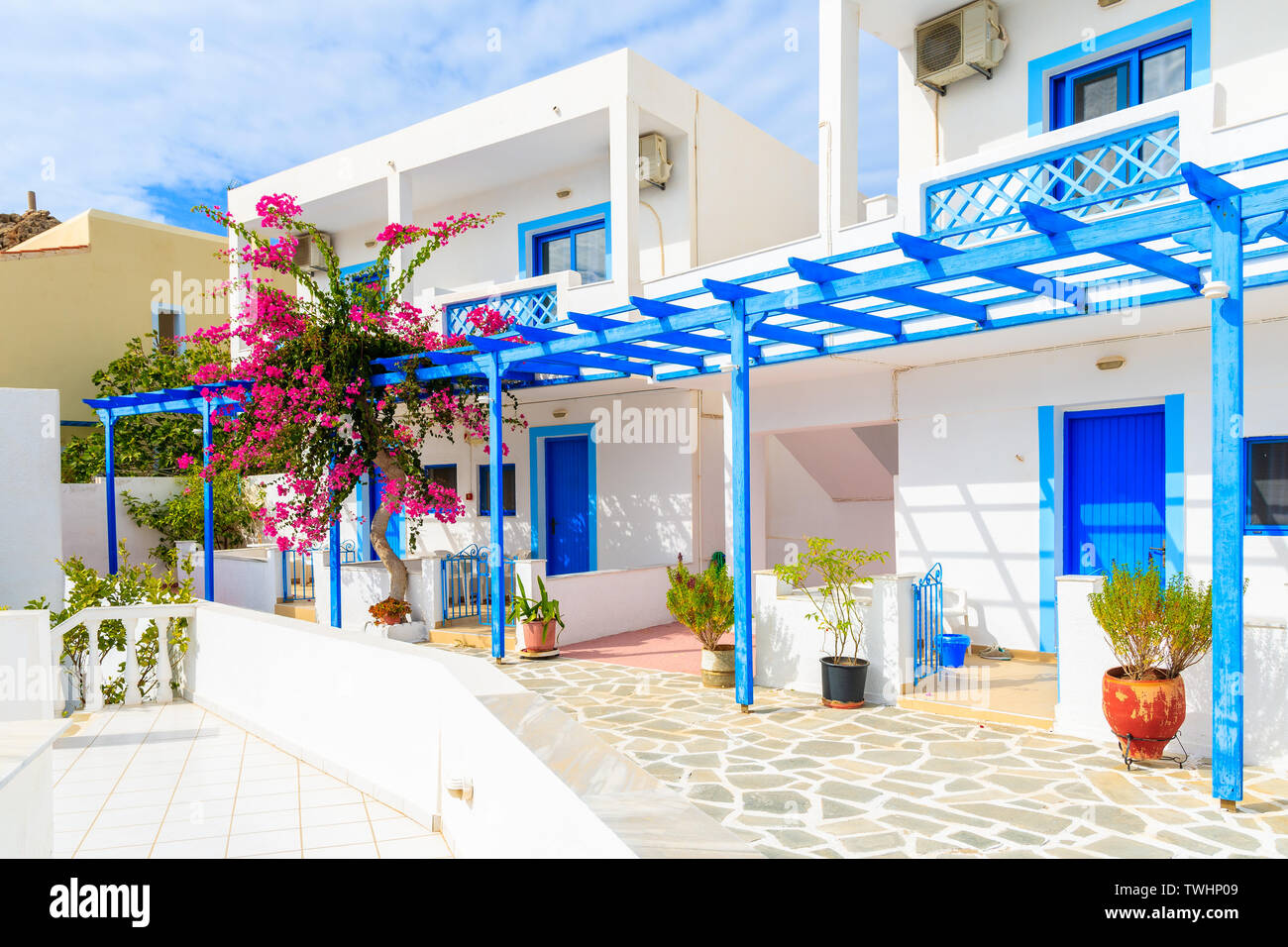 Die typischen weißen Häuser mit blauen Türen und Blumen in Ammopi Dorf, Karpathos, Griechenland Stockfoto