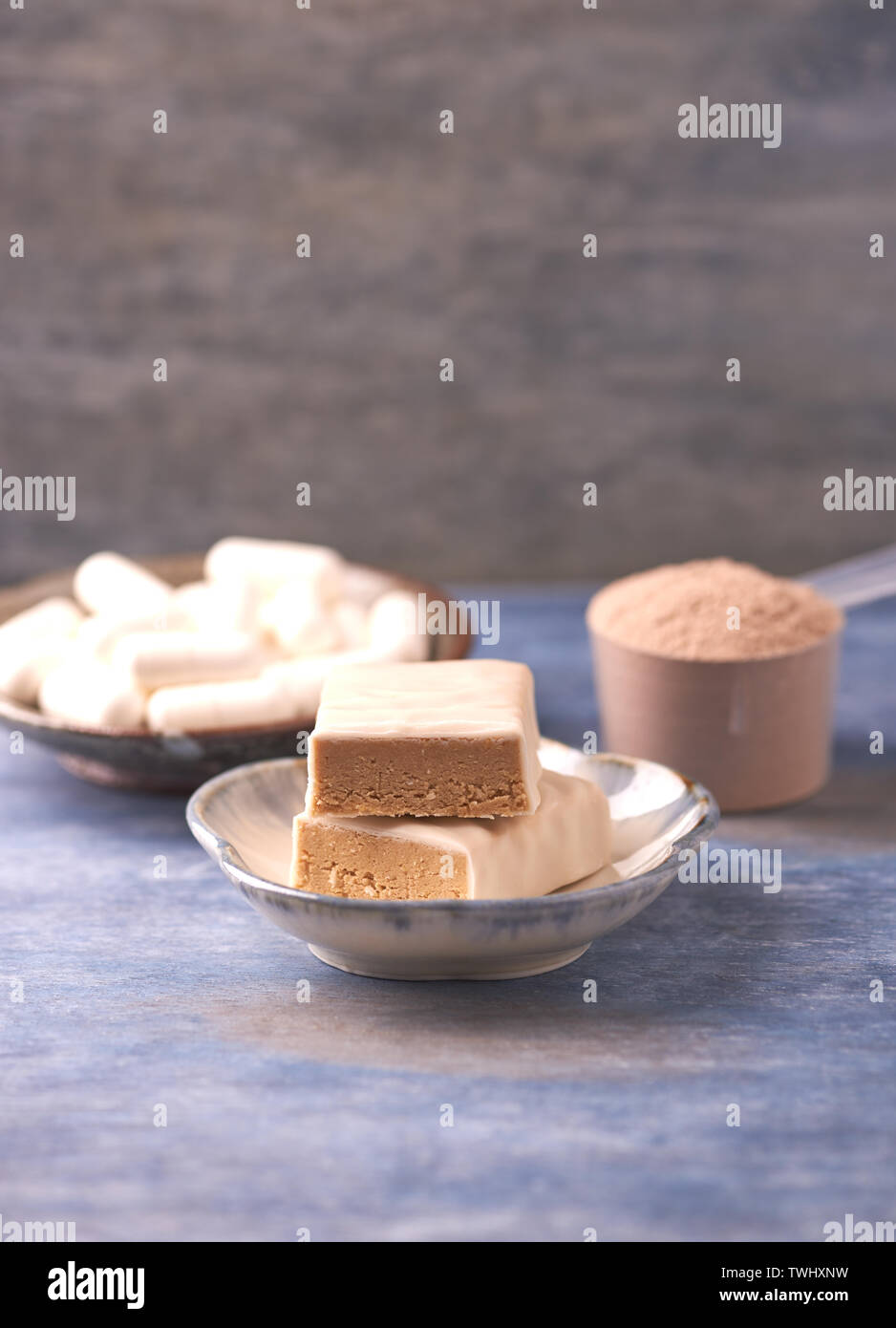 Protein Bar in zwei Stücken, Creatin Kapseln und Schaufel. Bodybuilding Nahrungsergänzungen auf rustikalen Holzmöbeln Hintergrund. Kopieren Sie Platz. Stockfoto