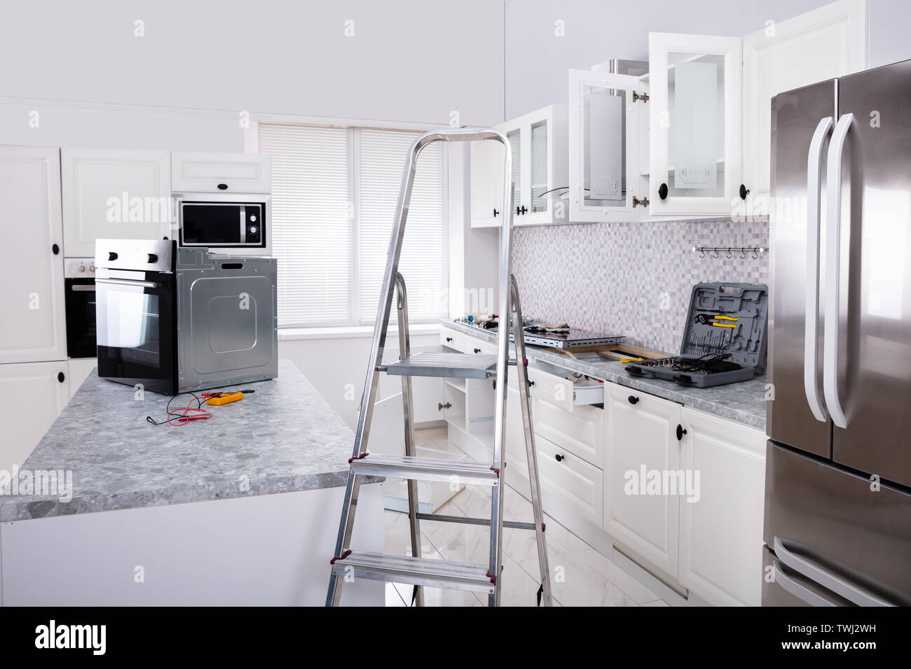 Einbau der neuen Micro Backofen und Induktionsherd in der modernen Küche Stockfoto