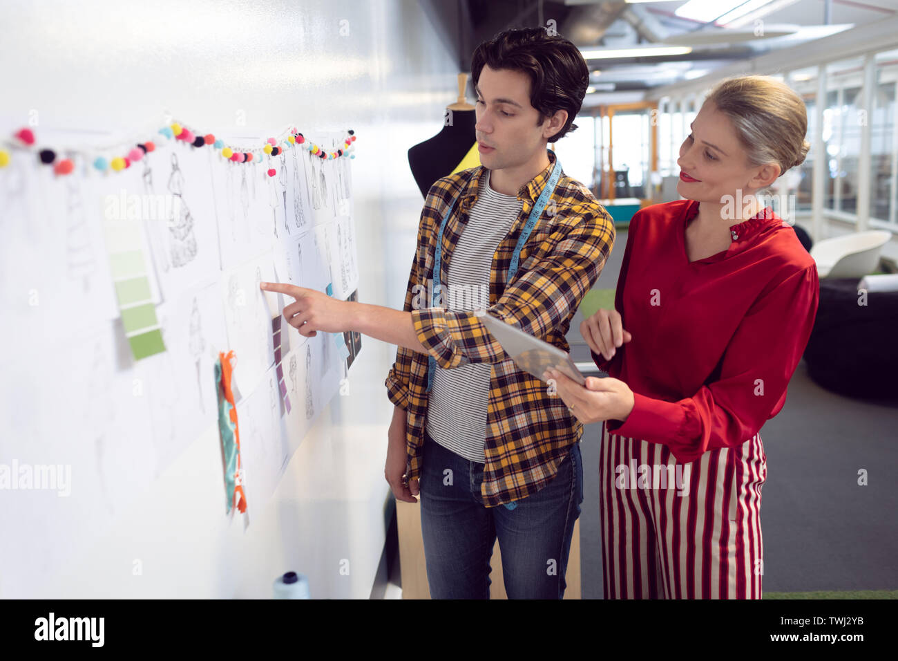 Männliche und weibliche Mode Designer diskutieren über Skizze Stockfoto