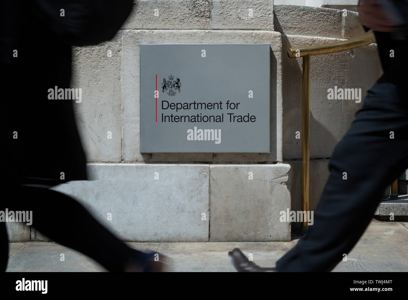 Fußgänger vorbei an der Abteilung für Internationalen Handel Zeichen außerhalb der Staatlichen Abteilung in London, UK. Stockfoto