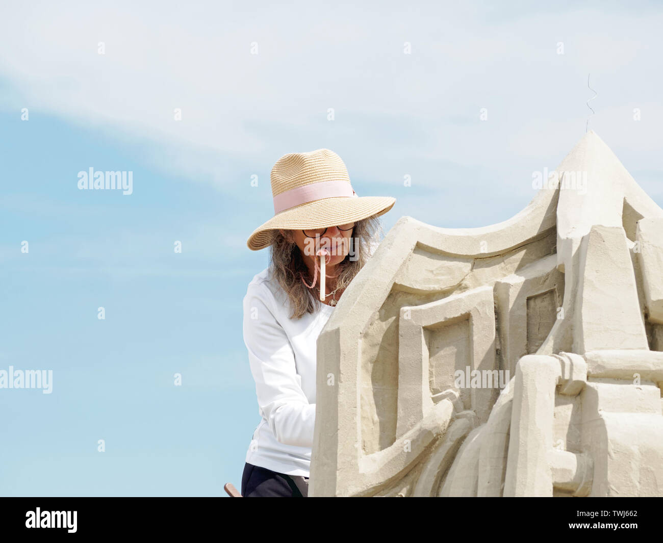 Lucinda Wierenga, mouthing ein Schlag Rohr, formt ihr Master Duo Eintrag", Bogen zu ihren Oberherren, 'Am2019 Texas Sandfest in Port Aransas, Texas USA. Stockfoto