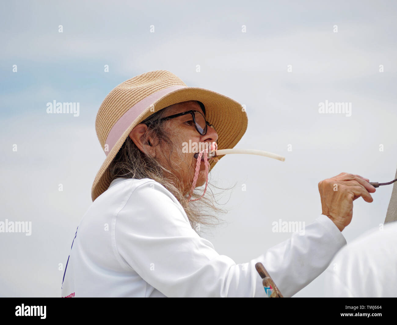 Lucinda Wierenga, mouthing ein Schlag Rohr, formt ihr Master Duo Eintrag", Bogen zu ihren Oberherren, 'Am2019 Texas Sandfest in Port Aransas, Texas USA. Stockfoto