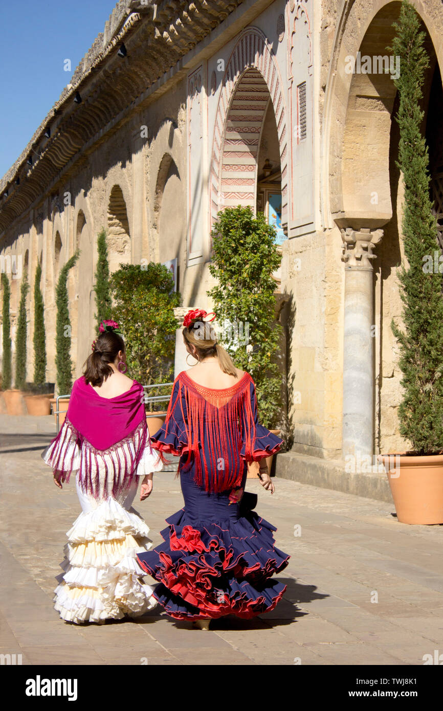 Zwei spanische Dame im nativen Kostüme für eine regionale Veranstaltung Spaziergang entlang der Seite der Moschee/Kathedrale in Cordoba, Spanien. Stockfoto