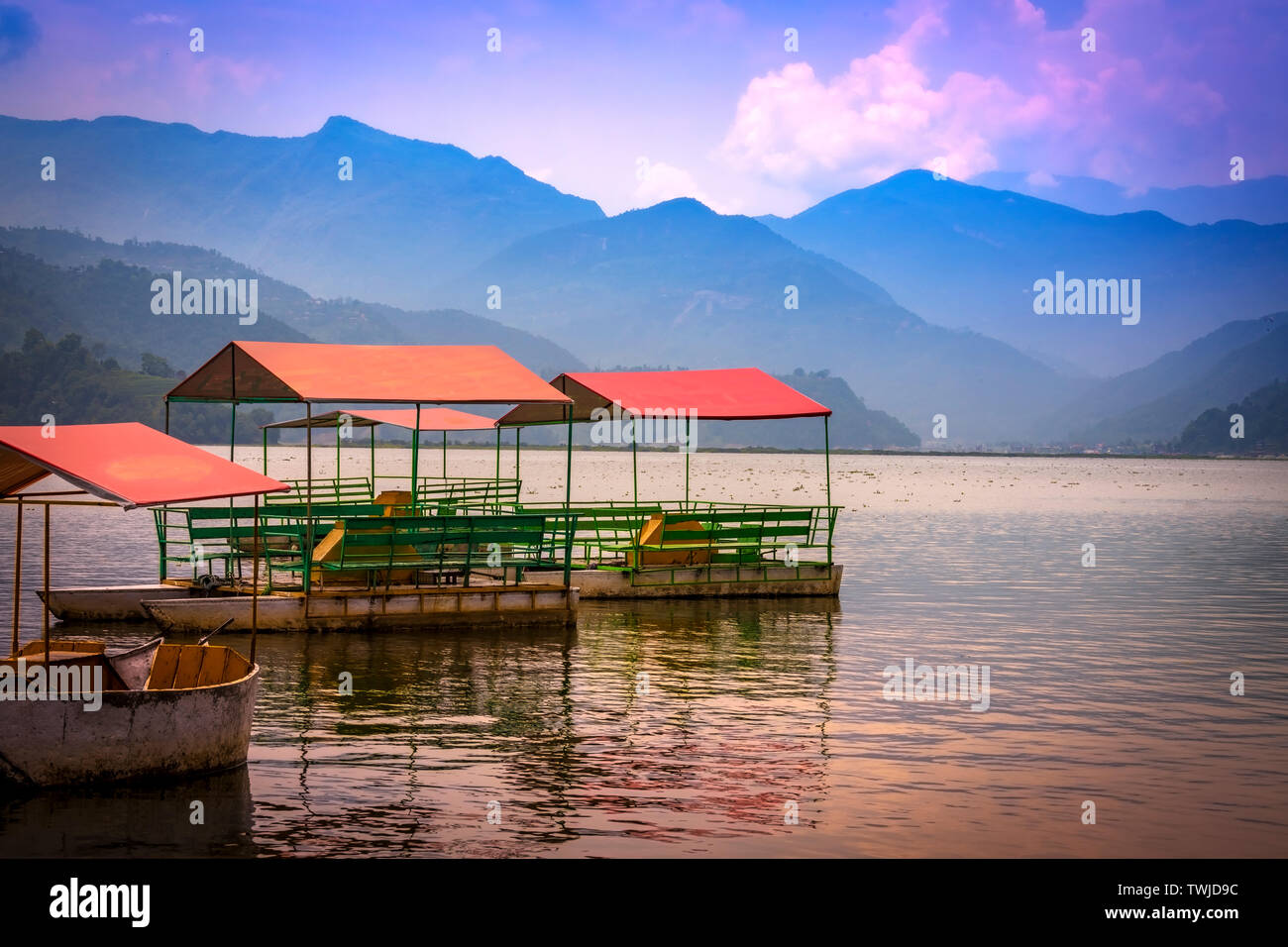 Bunte Tretboote geparkt In Phewa See, Blue Hills und Sonnenuntergang Wolken im Hintergrund Pokhara Nepal. Stockfoto