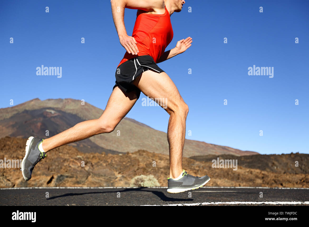 Laufender Mann-männliche Läufer training draußen Sprinten auf Mountain Road in atemberaubender Landschaft Natur. Nahaufnahme der stattlichen Jogger Arbeiten für Marathon im Sommer im Freien. Stockfoto