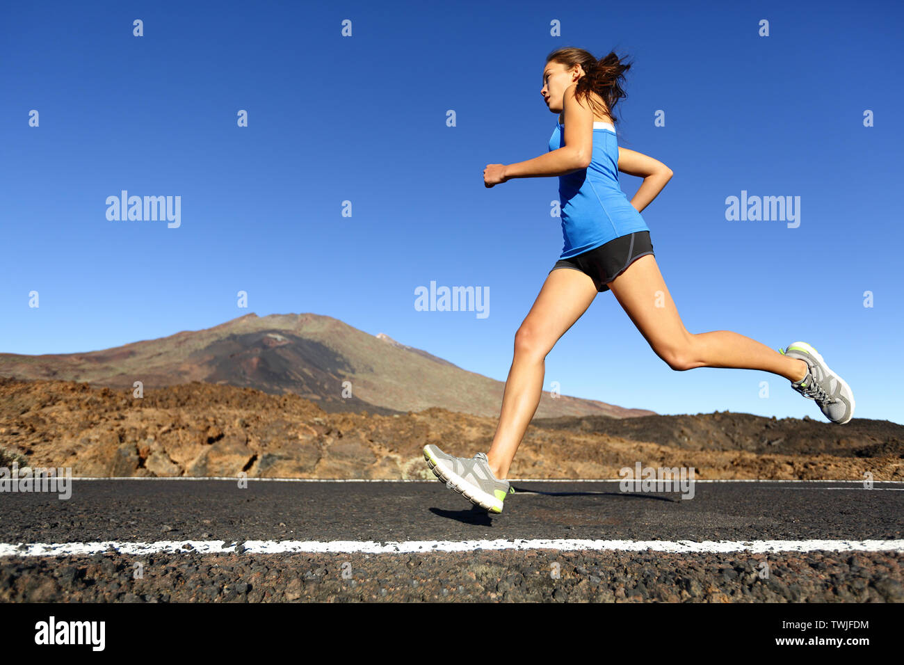 Sprinten, Frau - Läuferin Training im Freien joggen auf Mountain Road in atemberaubender Landschaft Natur. Passen schönen Fitness Modell arbeiten für Marathon im Sommer im Freien. Stockfoto