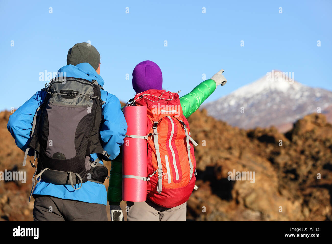 Wanderer auf der Suche nach Anzeigen, Wandern in die Berge. Menschen Wanderer Paar in der Natur Landschaft Trekking Rucksäcke tragen. Frau und Mann auf den Vulkan Teide, Teneriffa, Kanarische Inseln, Spanien Stockfoto