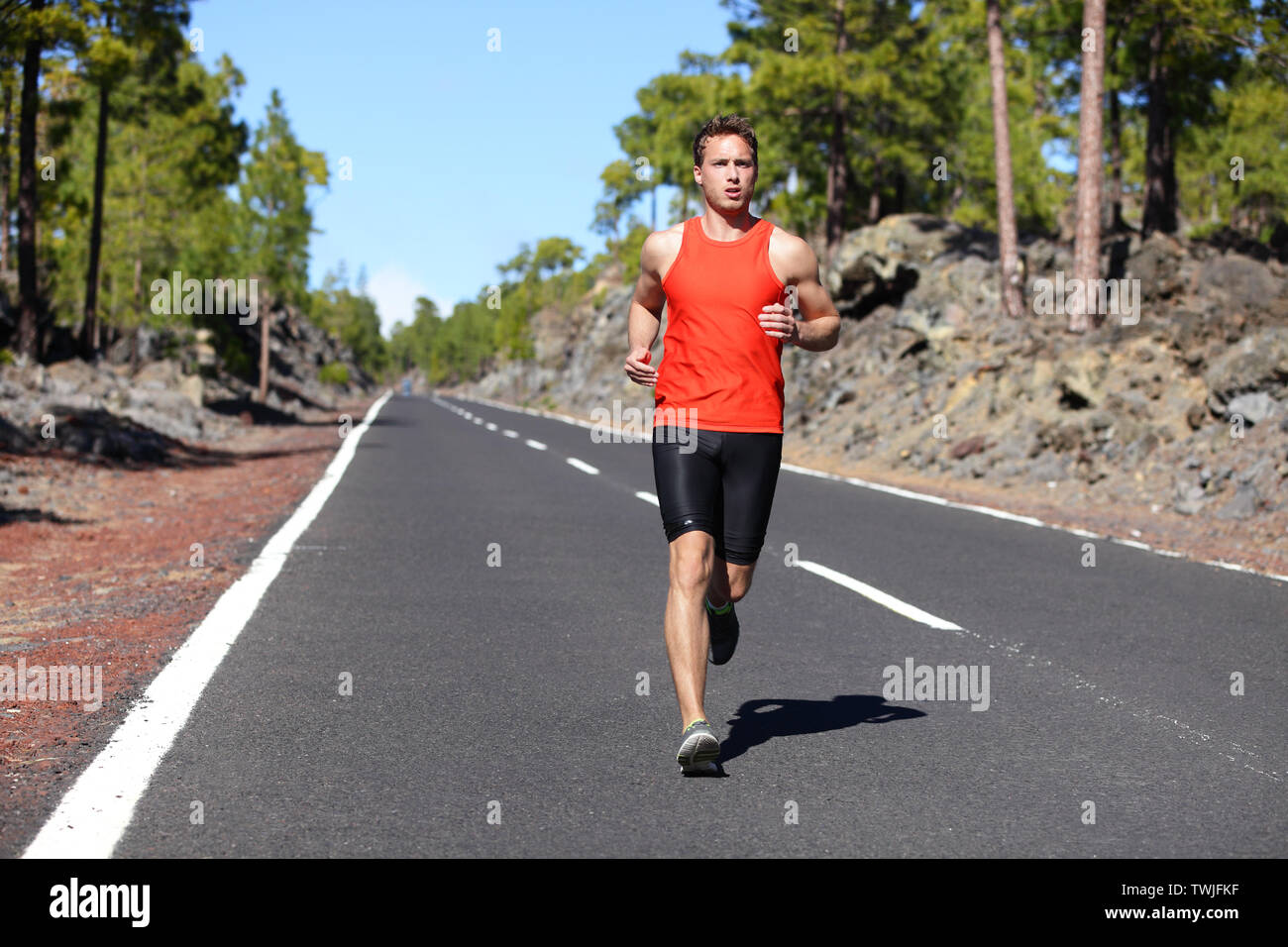 Laufender Mann-männliche Läufer joggen draußen auf der Straße Training für Marathon laufen als Teil eines gesunden Lebensstils. Nahaufnahme von fit Fitness Modell während Outdoor Training im Sommer. Kaukasische Kerl. Stockfoto