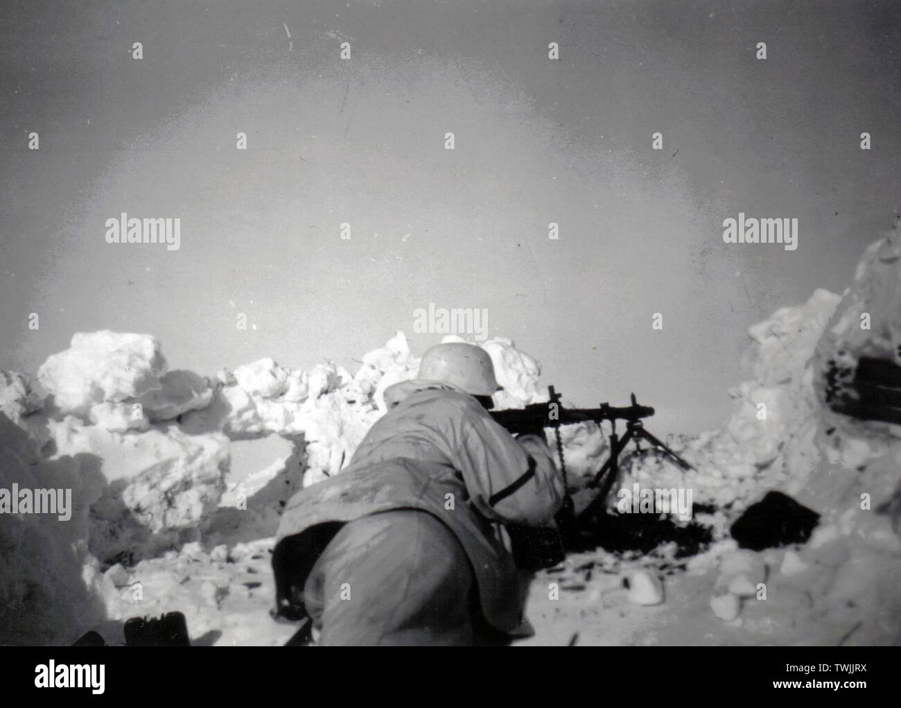 Deutscher Soldat in White Camouflage mit einem MG 34 in einem Graben an der russischen Front 1943 Stockfoto