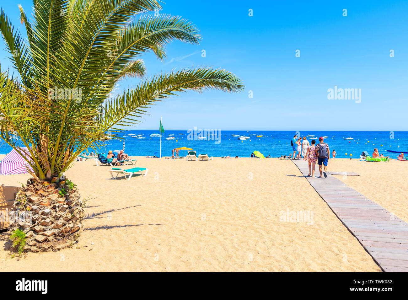 TOSSA DE MAR, SPANIEN - Jun 3, 2019: Menschen zu Fuß am Sandstrand in Tossa de Mar, Costa Brava, Spanien. Stockfoto