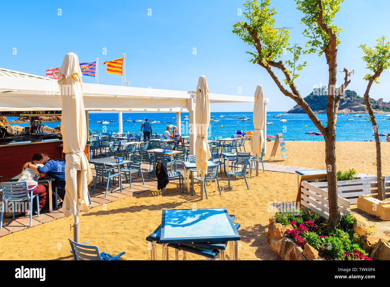 TOSSA DE MAR, SPANIEN - Jun 3, 2019: Die Menschen essen im Restaurant am Strand von Tossa de Mar, Costa Brava, Spanien. Stockfoto