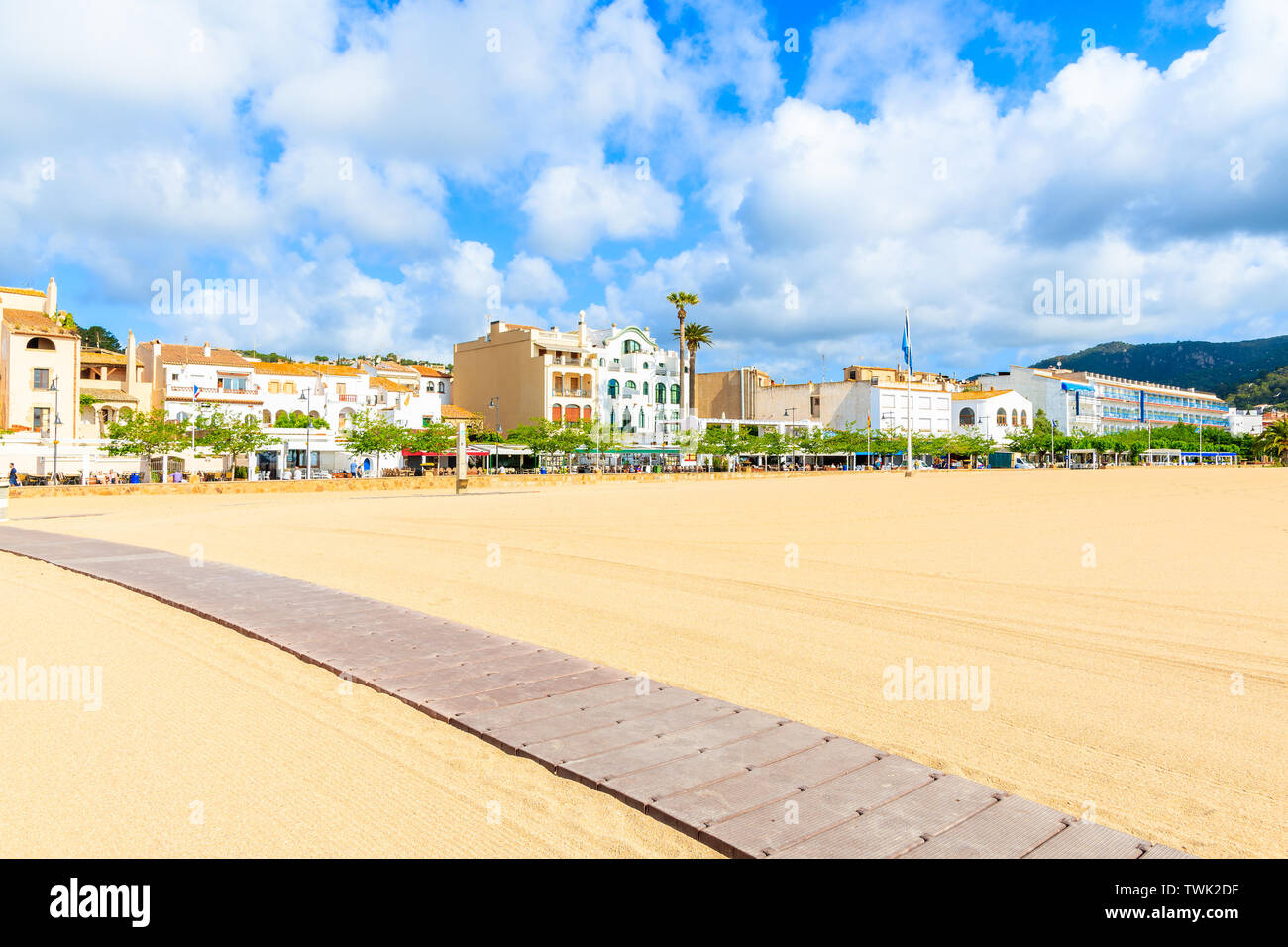 Pfad auf dem Sandstrand in Tossa de Mar mit bunten Häuser im Hintergrund, Costa Brava, Spanien Stockfoto