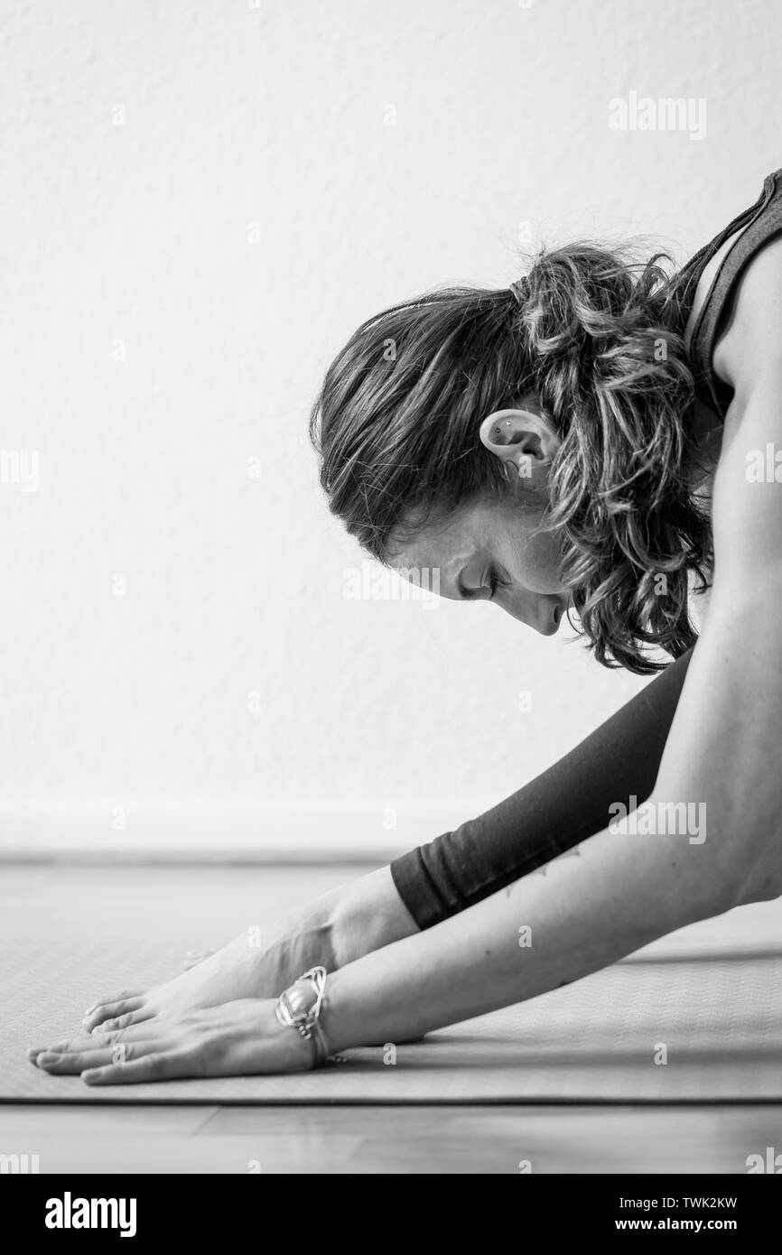 Seitliche Sicht auf eine junge Frau in den frühen 30er Jahren die astanas oder Haltungen in der Praxis des Yoga. Stockfoto