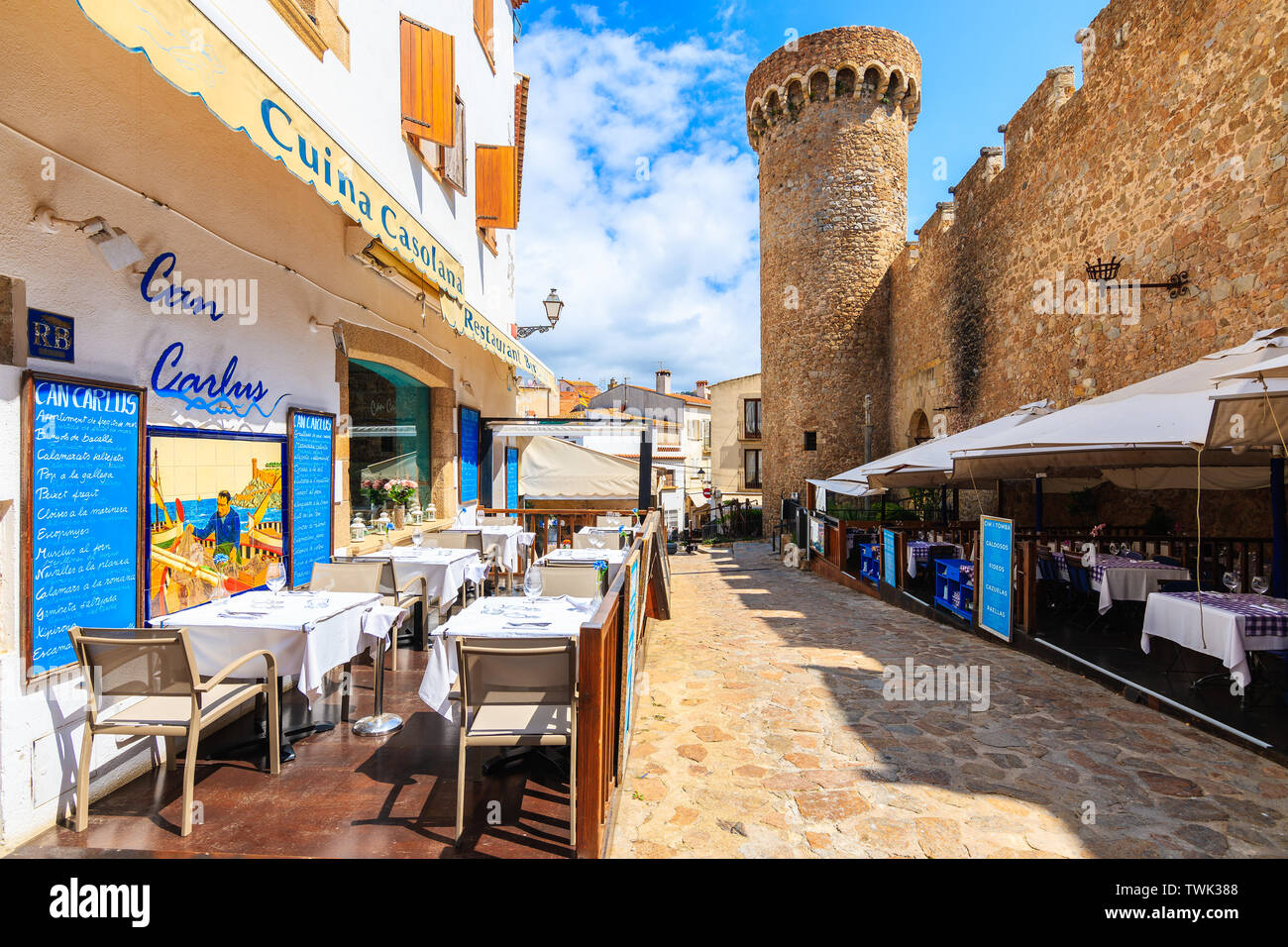 TOSSA DE MAR, SPANIEN - Jul 6, 2019: Restaurant Tabellen in die wunderschöne Altstadt von Tossa de Mar, das ist ein Badeort an der Costa Brava, Spanien. Stockfoto