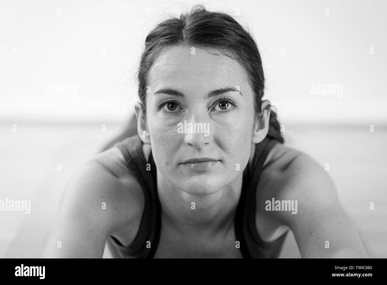 Porträt einer jungen europäischen Brünette, die in ihrem Zuhause eine Yoga-Pose oder Asana spielt Stockfoto