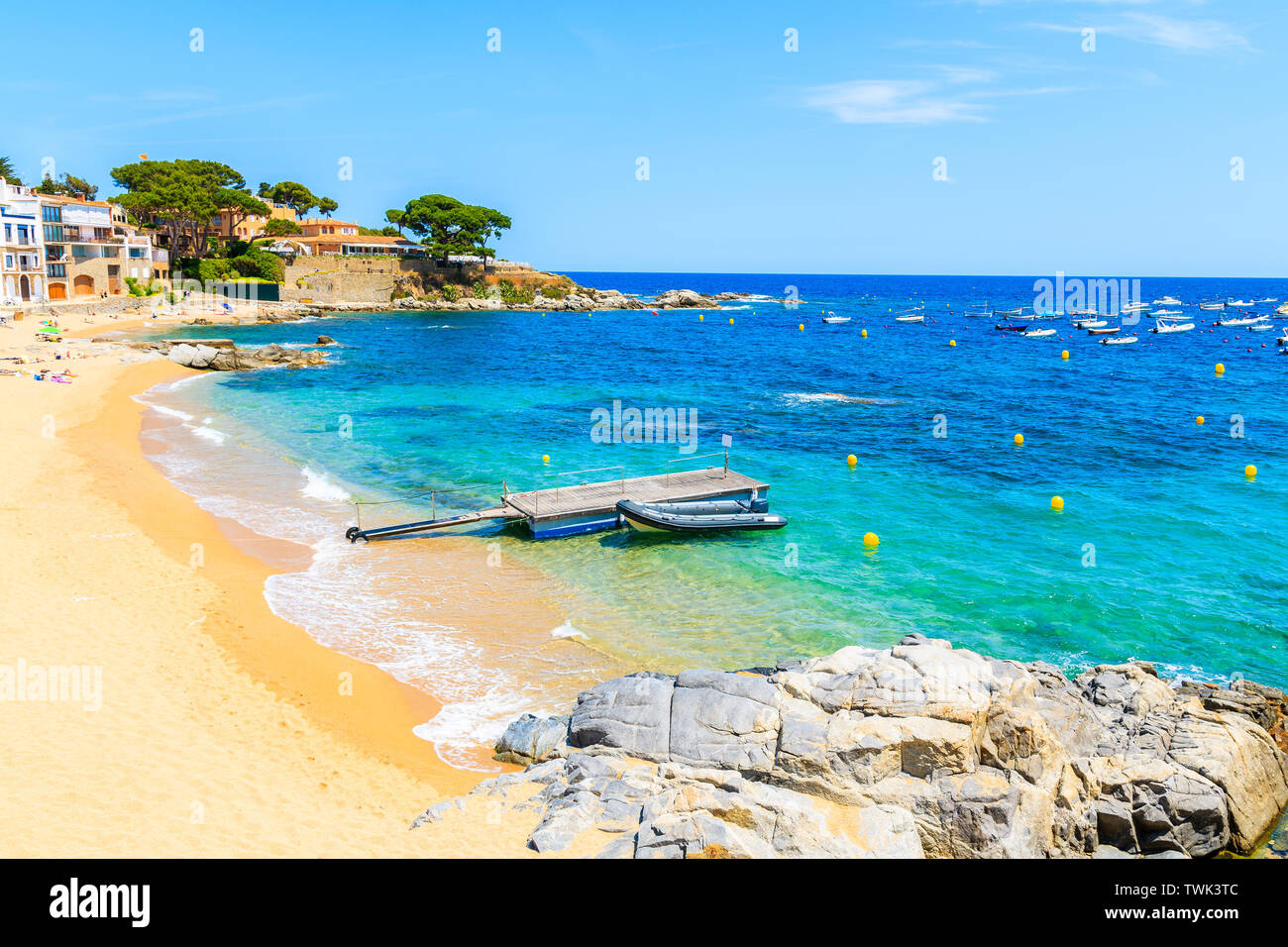 Boote auf canadell Strand von Calella de Palafrugell Dorf mit Häusern am Ufer, Costa Brava, Katalonien, Spanien Stockfoto