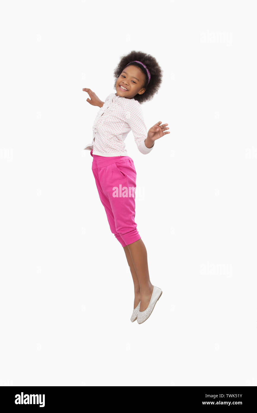Mädchen in die Luft springen und lächelnd Stockfoto