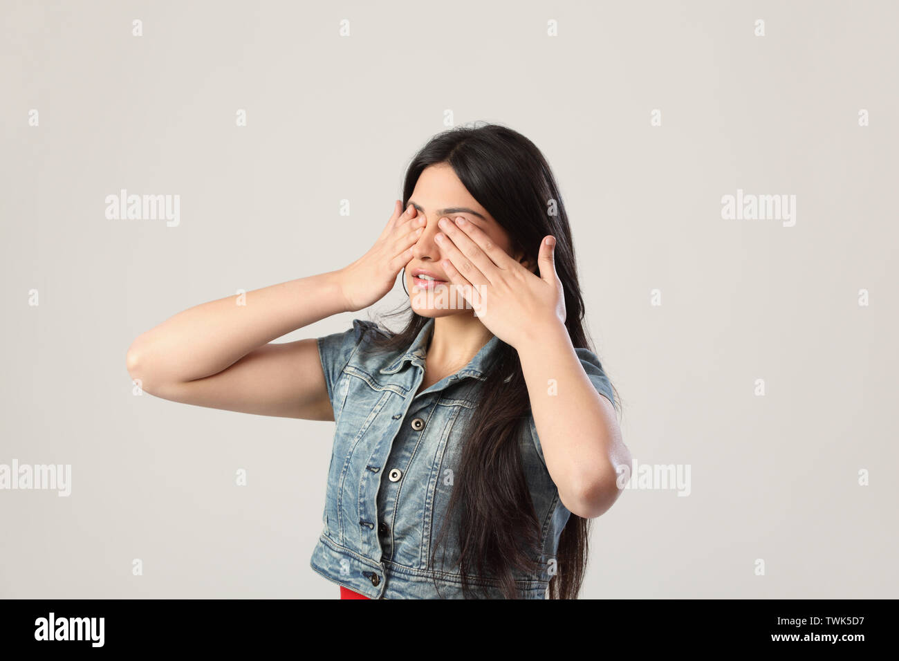 Frau, die Augen mit den Händen Stockfoto